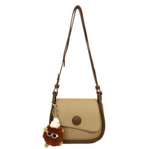 Women stylish crossbody bag with cute plush charm, chic brown shoulder bag for daily use.