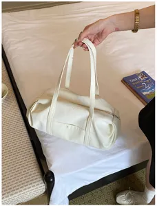 White leather shoulder bag detail, stylish minimalist barrel bag lifestyle shot, elegant daily wear.