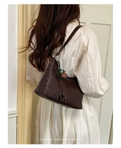 Detailed shot of a woven dark brown shoulder bag, showcasing intricate texture and retro vibe.
