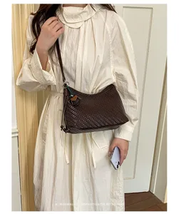 Vista dettagliata dell'elegante borsa a tracolla intrecciata marrone scuro, ottima fattura.