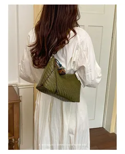 Vista dettagliata della borsa a spalla intrecciata verde, borsa hobo retro con ciondolo chic.