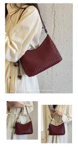 Detail view of a burgundy woven leather shoulder hobo bag worn by model, stylish retro vibe.