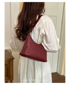Vista dettagliata della borsa a spalla intrecciata chic in bordeaux per un look elegante.