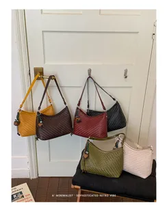Detailed shot of stylish woven shoulder bags in multiple colors, featuring premium PU leather design.