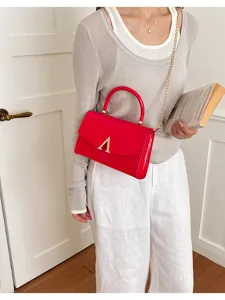 Borsa a tracolla quadrata rossa lucida con catena dorata e chic dettaglio con fibbia ad A.