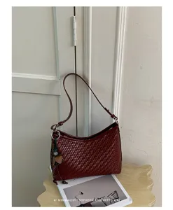 Primo piano della borsa a spalla in pelle intrecciata rosso scuro, design retrò chic.