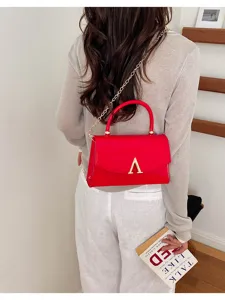 Elegante borsa a tracolla in pelle verniciata rossa con catena oro e chiusura V.