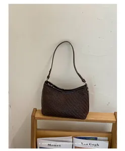 Primo piano dettagliato della borsa a spalla intrecciata marrone scuro in elegante stile retro.