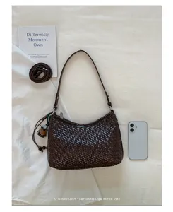Detailed flat lay shot of dark brown woven shoulder bag with chic retro vibe and delicate strap.