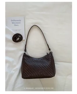 Detailed view of the dark brown woven underarm bag, showcasing fine texture and minimalist strap.