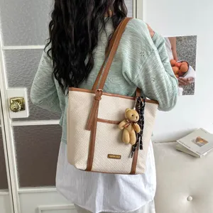 Casual canvas tote bag for women with brown leather trim, cute teddy bear pendant and shoulder strap.