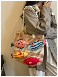 Nahaufnahme der stylischen handgemachten Stricktasche mit niedlichen Plueschfisch-Details.