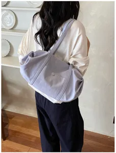 Minimalist purple fabric shoulder bag detail, soft slouchy daily tote for women casual wear.