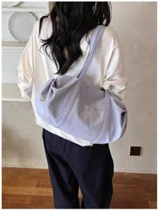 Detailed view of the soft light purple shoulder bag, showing large capacity and comfortable strap.