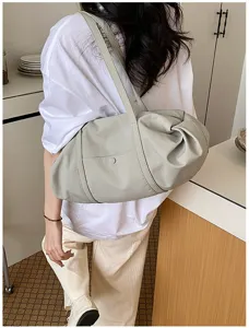 Detailed view of grey shoulder bag worn by model, showing casual everyday style and texture.