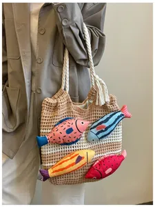 Detailaufnahme der handgearbeiteten Häkel-Umhängetasche mit bunten Plüschfisch-Dekorationen.