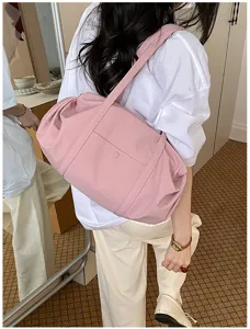 Detailed shot of a pink casual shoulder bag worn on the back, soft fabric and minimalist style.