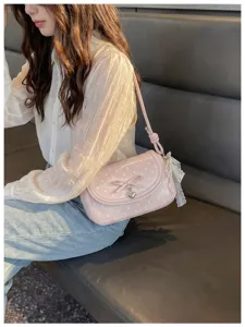 Sweet pink polka dot shoulder bag for women, cute bow and heart pendant crossbody handbag.
