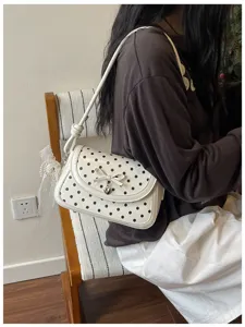 Cute polka dot shoulder bag for women with sweet bow and heart pendant, stylish casual daily purse.