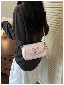 Sweet pink polka dot shoulder bag with cute bow detail, perfect for daily commuting wear.