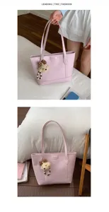 Pink tote bag detail shot showing cute plush bear pendant and high quality pu leather material.