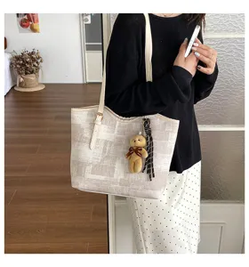 Close-up view of the casual tote bag with cute bear charm, elegant texture and spacious interior.