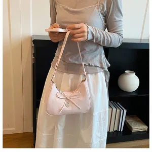 Sac épaule croissant rose minimaliste avec nœud, sac à main élégant pour femme active.