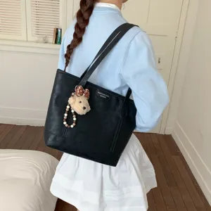 Black large capacity tote bag for women, stylish shoulder bag with cute bear pendant.
