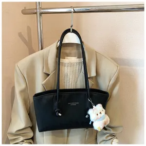 Retro black shoulder tote bag detail view, casual commuting large capacity design with cute keychain.