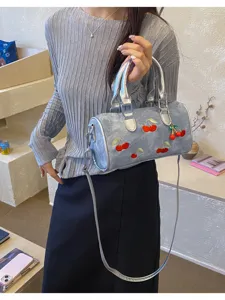 Stylish denim blue Boston shoulder bag with cute cherry embroidery and chic charm.