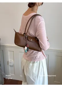 Minimalist leather underarm shoulder bag detail showing premium baguette shape and stylish charm.