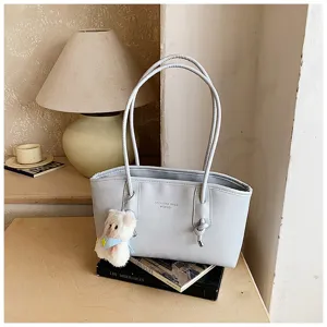 Detailed view of the stylish light blue shoulder tote bag with twin straps and cute pendant.