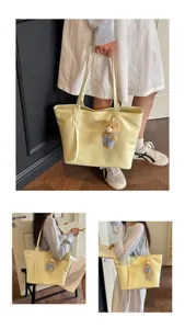 Detail view of yellow tote bag with bear pendant, showing daily styling and capacity.