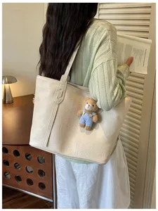 Minimalist large capacity PU leather tote bag for women, stylish shoulder bag with cute bear pendant.