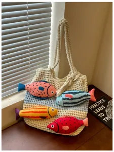 Nahaufnahme der gestrickten Tasche mit niedlichen bunten Plüschfischen und stabilen Griffen.