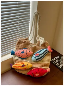 Nahaufnahme Detail der Strick-Tasche mit bunten Plüschfisch-Dekoren und stabilen Griffen.