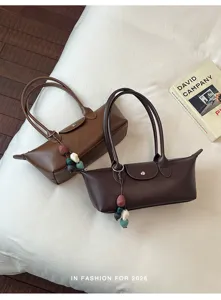 Elegant minimalist women's underarm shoulder bag, chic commuter leather tote with charm.