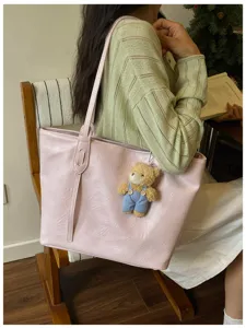 Pink PU leather tote bag for women, stylish casual shoulder bag with cute bear pendant.