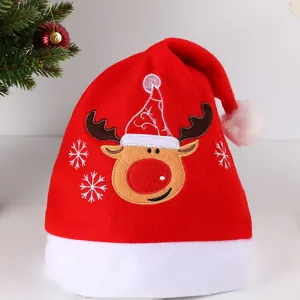 Détail de bonnet de Noël en peluche avec broderie de renne pour fête de fin d'année et vacances.