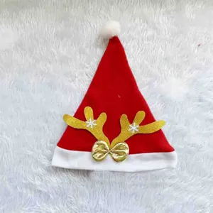 Détail de chapeau de Noël en peluche rouge avec bois de renne pailletés d'or et nœud.