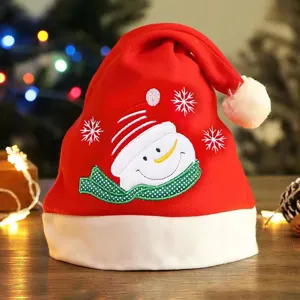 Bonnet de noël détail avec joli bonhomme de neige brodé et flocons sur tissu rouge doux.