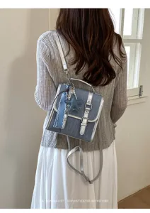 Détail du mini sac à dos en denim rétro avec accessoires argentés et joli pendentif.