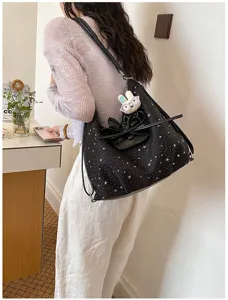 Vue détaillée du sac cabas femme noir imprimé étoiles avec nœud papillon élégant.