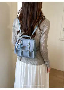 Vue arrière détaillée d'un mini sac à dos en jean bleu clair rétro avec pendentif étoile et bretelles.
