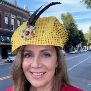 Primer plano detallado del sombrero de disfraz de lentejuelas amarillas con plumas.