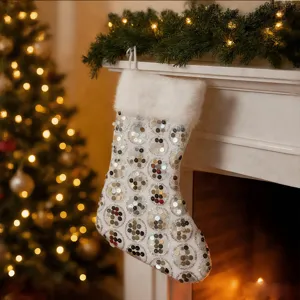 Détail de chaussette de Noël blanche à sequins avec manchette en peluche douce pour cheminée.