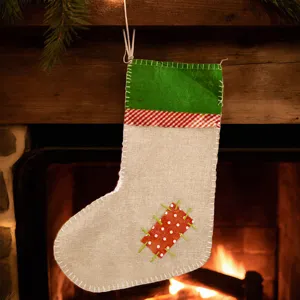 Large burlap Christmas stocking with green cuff, red stripe and polka dot patch for holiday decor.