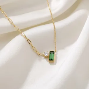 Gedetailleerde close-up van een groene zirkonia hanger ketting op zachte zijde stof.