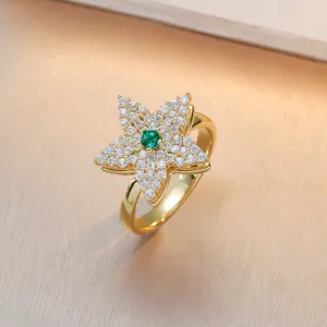 Gold-plated star flower ring with sparkling white zirconia and green center stone.