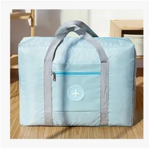 Detail view of the large capacity waterproof foldable travel bag with sturdy grey straps.